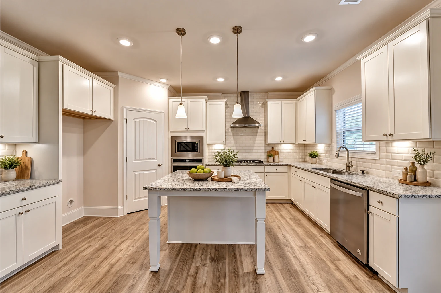 Kitchen with white cabinetry, granite island, gas cooktop and wall ovens — virtually staged